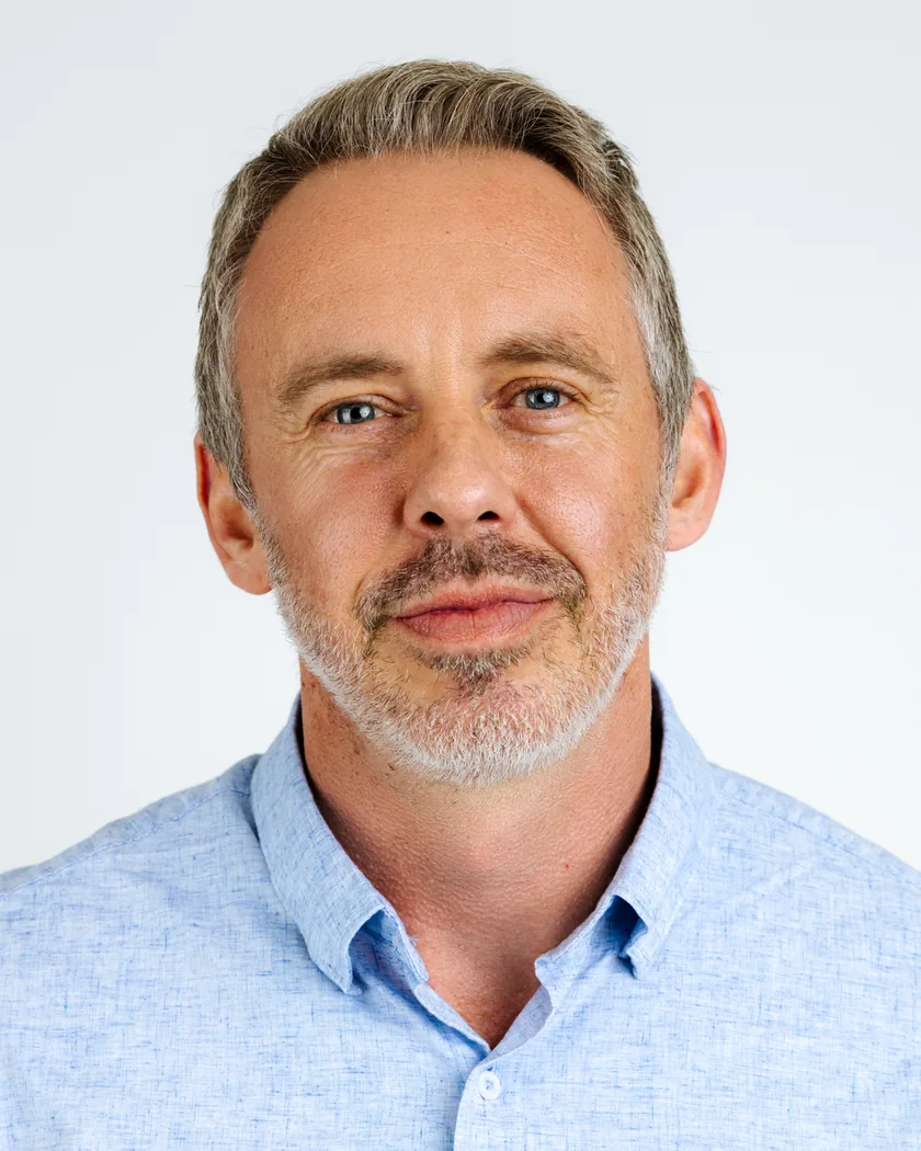 Dr. Reid Robison, Chief Medical Officer. A middle-aged man with gray hair and beard in a light blue button-up shirt, against a plain white background.